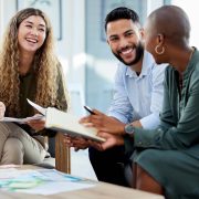 Happy business people smile during a planning meeting in a startup marketing agency office. Diversity, collaboration and teamwork in a healthy work environment in an international advertising company.